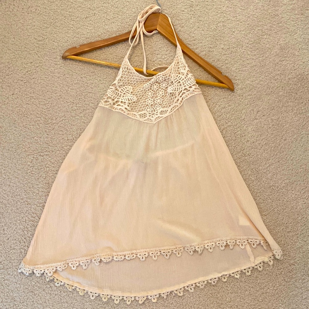 Adorable light tan summer top. High necked with tie and is partially backless.